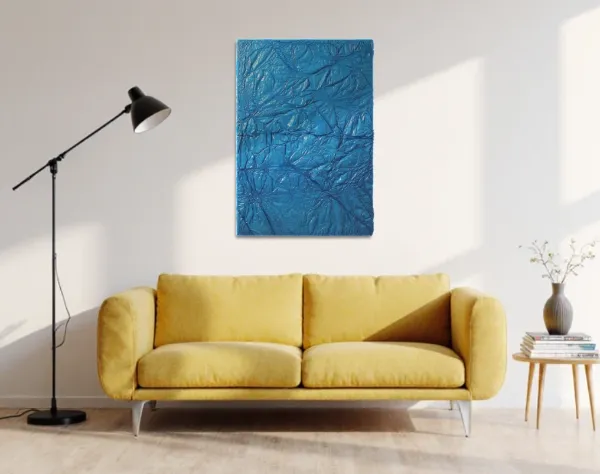 Eine Bild aus blauer Kunststofffolie, die durch starke Verwerfungen gekennzeichnet ist, hängt in einem Raum über einem Sofa. | wolfram schäfers