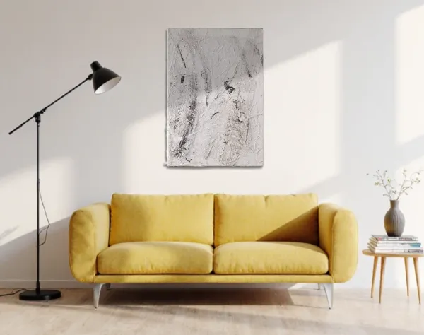 Abstraktes Bild aus weißer und schwarzer Acrylfarbe mit einer Kunststofffolie überzogen. Das Bild, das den Eindruck einer Tundra Aufnahme aus dem Weltraumaufnahme erweckt, hängt in einem Raum über einem Curry farbigem Sofa. | mixed-art - wolfram schäfers