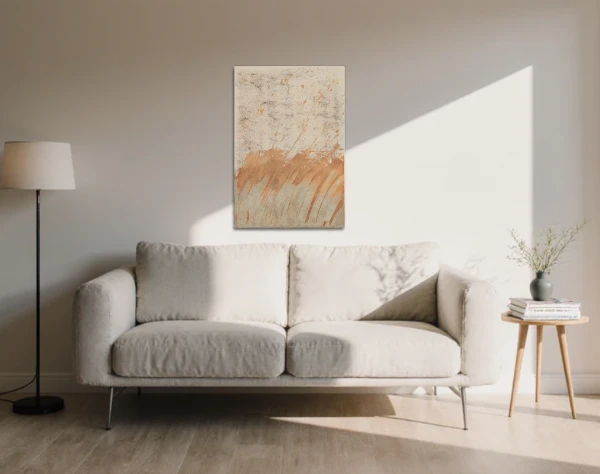Abstraktes Bild auf einer Leinwand über einem hellen Sofa in einem Wohnraum. Zarter Auftrag einer teilweise oxidierten, grauen und hellbeigebraunen Oxydmischung und die darüber liegende hellbeige Fläche, lassen die Anmutung einer herbstlichen Landschaft im Sturm entstehen. Von dem zeitgenössischen Künstler Wolfram Schäfers. – mixed-art